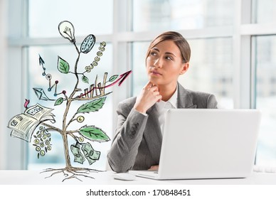 Concept Of Growing Company With Sketch Of A Plant With Business Symbols And Businesswoman Working On Laptop