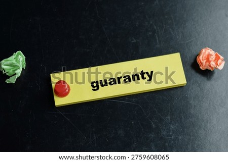 Concept of guaranty write on sticky notes isolated on Wooden Table.
