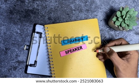 Concept of Guest Speaker write on sticky notes isolated on Wooden Table.