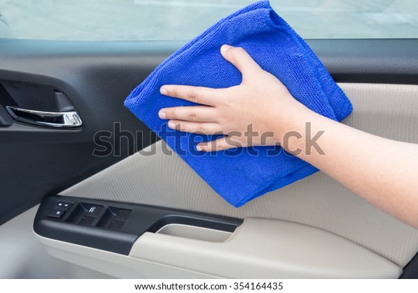 Concept of Hand cleaning interior car door panel\
with microfiber cloth