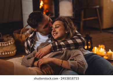Concept of happy family relationships between man and woman. Young couple relaxed near fireplace in a cottage countryside house. Cozy atmosphere, calm lazy weekend, slow living , simple pleasures - Powered by Shutterstock