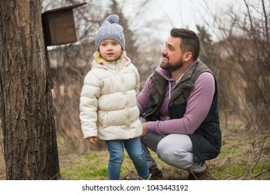 The Concept Of A Happy And Interesting Childhood. Father And Child Are Having Fun. Father And Daughter Make A Bird Feeder.