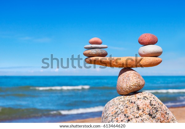 Concept of harmony and balance.\
Balance stones against the sea. Rock zen in the form of\
scales