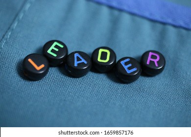 Concept Of Healthcare Leadership With A Closeup Of The Word LEADER And Hospital Greens As The Background.