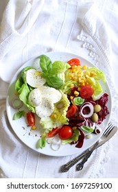 Concept of healthy food. Fresh salad with  mozzarella cheese on a plate. White background. Top view. Mediterranean food.
