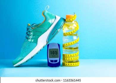 Concept Of A Healthy Lifestyle. Diabetes. Sugar Diabetes. Sports Diabetics. Detox Water, Glucose Meter, Measuring Tape And Sneakers On A Blue Background.