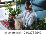 Concept of healthy lifestyle. Portrait of young African American woman doing yoga and meditation before work for concentration at home in the morning in living room. Every day morning ritual, routine