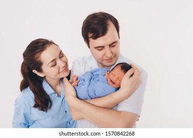 The Concept Of A Healthy Lifestyle, The Protection Of Children, Shopping - Baby In The Arms Of The Mother And Wather. Woman And Man Holding A Child