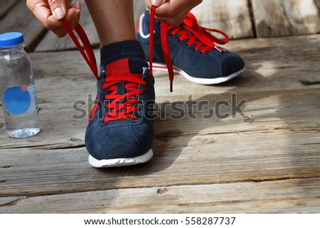Concept: healthy lifestyle,  Running shoes - closeup of woman tying shoe laces. Female sport fitness runner getting ready for jogging