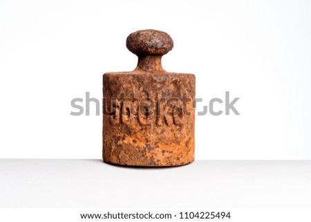 Concept of heavy and light. Rusty weight isolated on white background.