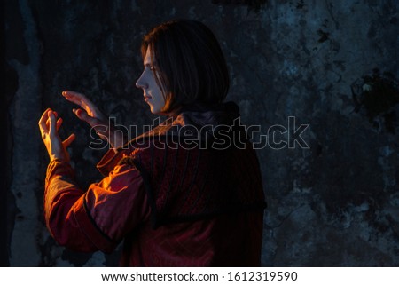 Concept of the history of science. A young man in the image of a medieval scientist holding something in his hand, place for your design