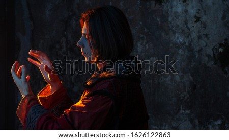 Concept of the history of science. A young man in the image of a medieval scientist holding something in his hand, place for your design