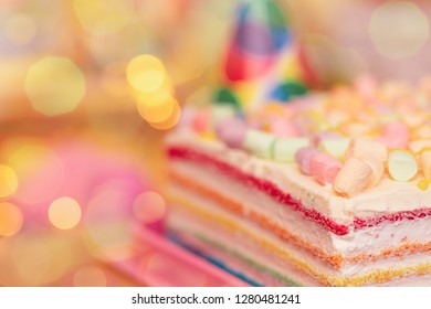 Concept Of Holiday Or Birthday. Multicolor Five Layer Cake With Colored  Marshmallow On The Top And Defocused Lights As Background