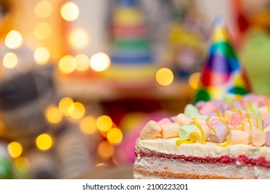 Concept Of Holiday Or Birthday. Multicolor Five Layer Cake With Colored Marshmallow On The Top And Defocused Lights As Background