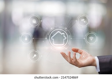 Concept of home control . A hand shows a house with a control interface. - Shutterstock ID 2147524869