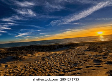 Concept of hope and tranquility, featuring a glowing sun setting over the horizon with textured sand dunes in the foreground.