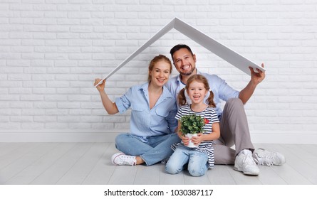 concept housing a young family. Mother father and child in new house with a roof at empty brick wall