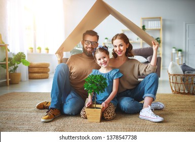 Konzept für eine junge Familie. Mutter Vater und Kind im neuen Haus mit Dach zu Hause