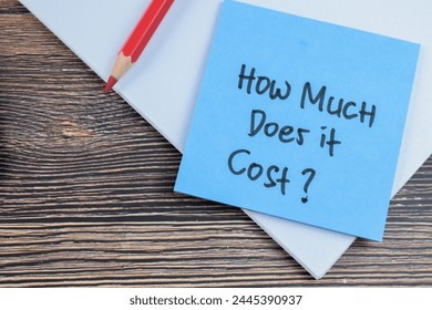Concept of How Much Does it Cost? write on sticky notes isolated on Wooden Table.