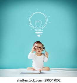 Concept, Idea Of Happy Little Baby With Bulb At Blackboard, Creative Of Baby And Genius Concept