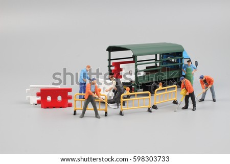 concept idea image of mini engineer dolls fixing cracked asphalt road 