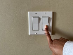 Une Image Conceptuelle D'une Personne Noire Qui éteint Un Interrupteur électrique Pour économiser De L'argent 