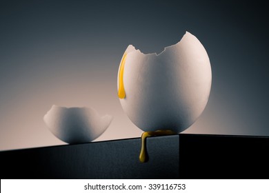 Concept Image Of A Broken White Egg Shell With Dripping Yolk