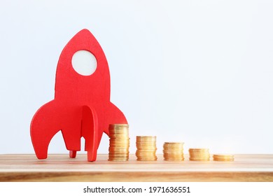 Concept image of coins stack and red rocket symbolling growth and profit