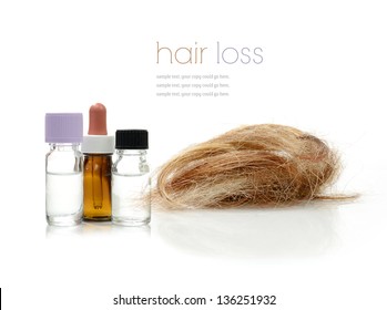 Concept image depicting alternative treatments for hair loss with medication bottles and hair piece against a white background. Copy space.