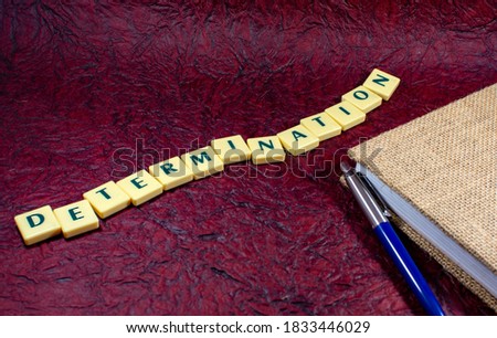 Concept image of Determination in texture background Ballpoint pen and a spiral diary for office or study use on red texture background