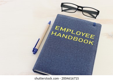 Concept Image Of Employee Handbook Over Wooden Office Table. Top View