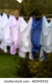 Concept Image For Having A Bad Day, Unlucky, Poor Judgement Etc. Clean Laundry Drying On The Washing Line In The Rain. Focus On The Window Highlighting The Rain Drops.