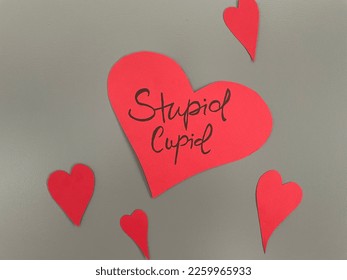A concept image of a heart with stupid cupid written on it as an anti Valentine's day message
