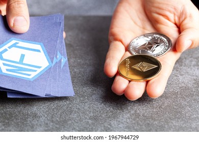 A concept image for investing in Non Fungible Tokens (NFTs) through Ethereum blockchain. These are rare digital items that are traded online. Image shows a woman holding NFTs with ETH coins