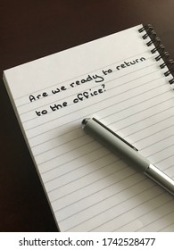 A Concept Image Of A Notebook With The Words “are We Ready To Return To The Office?” On It 