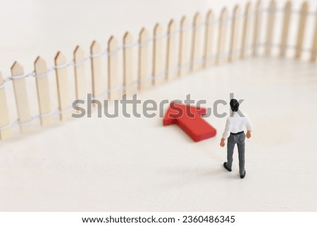 Concept image of person facing fence obstacle and thinking about solution. Idea of overcoming barrier and problems