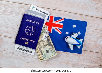 Concept Of Immunity To Coronavirus. Certificate Stating That Person Is Not Contagious. Passport With Note Covid-19 Test Passed, Money, Vaccine Bottle And A Toy Plane On Flag Of New Zeland