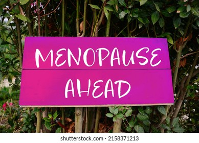 Concept of impending climacteric. Green bush with sign MENOPAUSE AHEAD outdoors - Shutterstock ID 2158371213