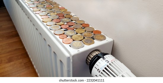 The concept of an impending energy crisis and the high cost of heating. Close-up of a heating radiator on which there are a lot of coins - Shutterstock ID 2232041111