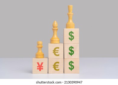 The Concept Of The Importance Of Currencies In The World Economy. Symbols Of Price, Yuan Dollar And Euro On Wooden Cubes On Which There Are Chess Pieces. The Global Financial System.