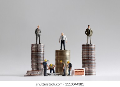 The Concept Of Income Gap. The stack of coins with miniature people.