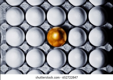 Concept Of Individuality, Exclusivity, Better Choice. One Golden Egg Among White Eggs In  Carton Tray, Top View.