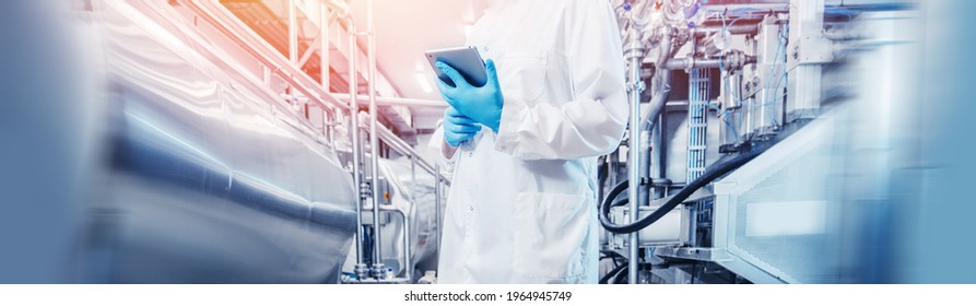 Concept industry food banner. Plant worker inspecting production line tanker in of beer or dairy factory with computer tablet. - Powered by Shutterstock