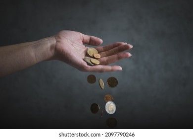 Concept Of Inflation. Woman Hand Hold An Euro Coins. Euro Coins Falling From Woman Hand. Declining Value Of Money - Inflation.