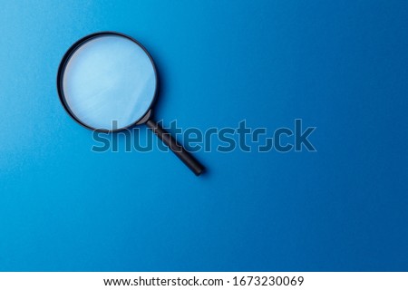 Concept information search. Magnifying glass on classic blue background. Top view. Flat lay. Copy space. Minimal creative concept. Trendy color. Searching information data on internet