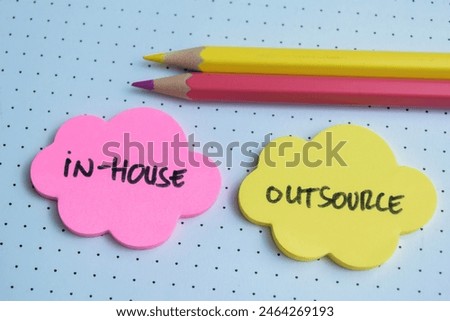 Concept of In-House or Outsource write on sticky notes isolated on Wooden Table.