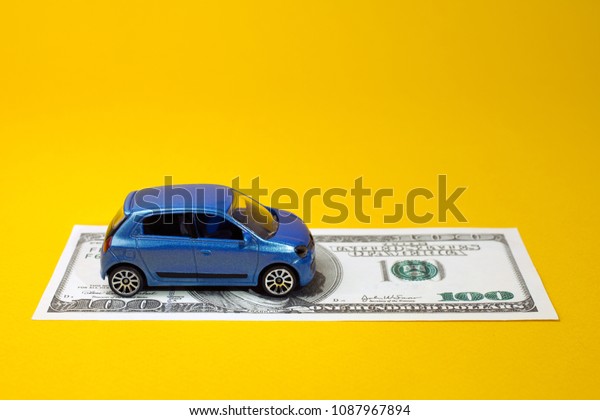 concept of insurance, credit and car purchases,\
leasing, car loan,  Auto dealership and rental, new car buy. toy\
car dollar bill