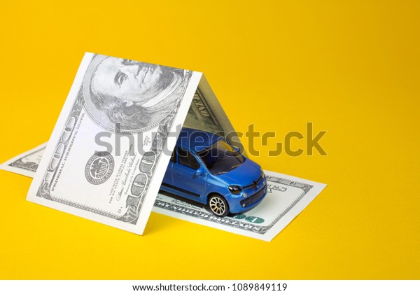 concept of insurance, credit and car purchases, car\
loan. toy car dollar\
bill