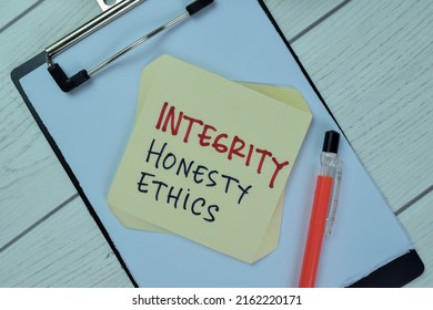 Concept of Integrity, Honesty and Ethics write on sticky notes isolated on Wooden Table.