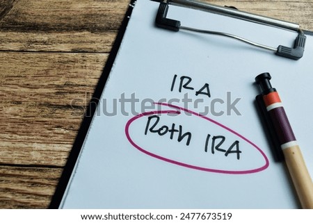 Concept of IRA and Roth IRA write on paperwork isolated on wooden background.